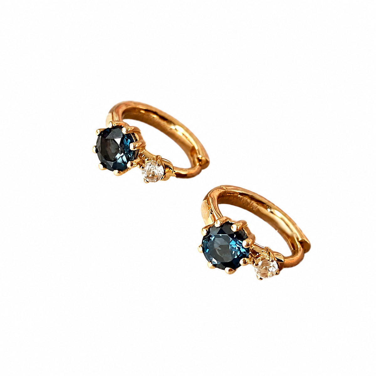 Blue zircon and clear accent hoop earrings in 18K gold-plated sterling silver, angled view on white